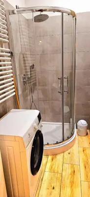 a shower with a glass door in a bathroom at M Apartment Bosacka 7 in Kraków