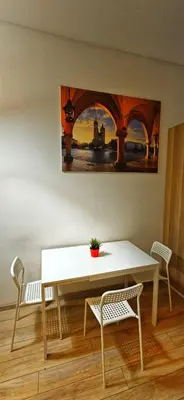 a table and chairs with a painting on the wall at M Apartment Bosacka 7 in Kraków