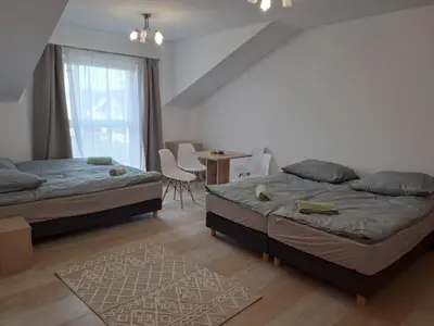 a bedroom with two beds and a table and chairs at Lawendlove in Kraków