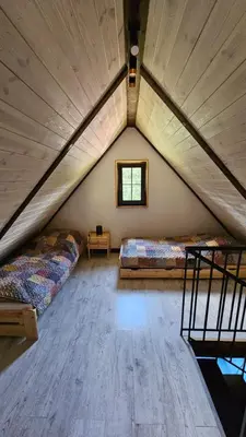 a attic room with two beds and a window at Wiśniowe Zacisze - Agroturystyka in Sułkowice