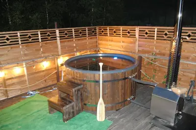 a large wooden tub sitting on top of a deck at Wiśniowe Zacisze - Agroturystyka in Sułkowice