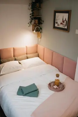 a large white bed with a tray of food on it at Celna Corner in Kraków