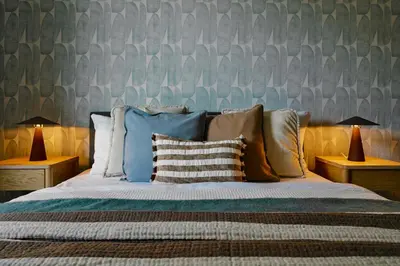 a bedroom with a bed with pillows and two lamps at Cosy Blue Cracow Apartment in Kraków