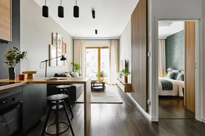 a kitchen and living room with a bed in a bedroom at Cosy Blue Cracow Apartment in Kraków