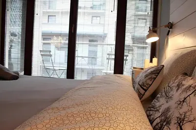 a bedroom with a bed and a large window at Kopernik-us 2 rooms - Old Town in Kraków