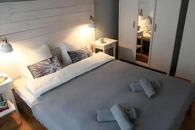 a bedroom with a large white bed with towels on it at Kopernik-us 2 rooms - Old Town in Kraków