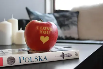 an apple with a heart written on it sitting on a book at Kopernik-us 2 rooms - Old Town in Kraków