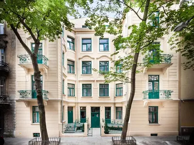 a building with a green door and trees at Apartamenty Bonerowska 5 in Kraków