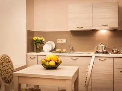 a kitchen with a table with a bowl of fruit on it at Apartamenty Bonerowska 5 in Kraków
