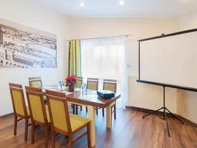 a dining room with a table and a white screen at Apartamenty Bonerowska 5 in Kraków