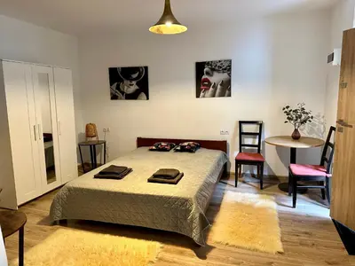 a bedroom with a bed and a table and chairs at Wolnica Apartament 1 in Kraków
