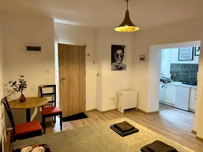 a living room with a table and a kitchen at Wolnica Apartament 1 in Kraków