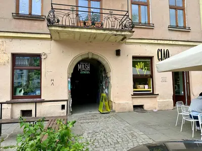 a door to a store with a balcony on top at Wolnica Apartament 1 in Kraków