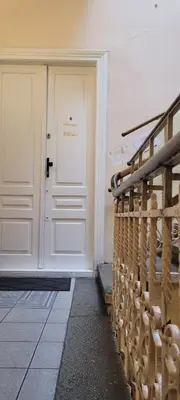 a white door with a sign on it next to a staircase at Cozy Apartment 4A in Kraków
