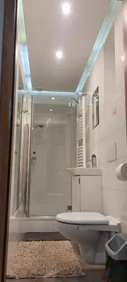 a bathroom with a shower and a toilet and a sink at Cozy Apartment 4A in Kraków
