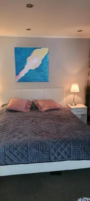 a bedroom with a bed with a painting on the wall at Cozy Apartment 4A in Kraków