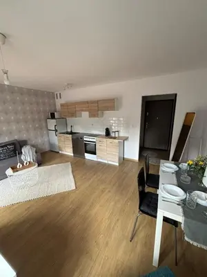 a living room with a table and a kitchen at Cozy Studio Apartment Krakow in Kraków