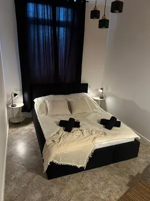 a bedroom with a bed with black headboard and pillows at La Ville - Rouge in Zator