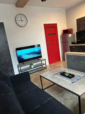 a living room with a couch and a tv and a red door at La Ville - Rouge in Zator