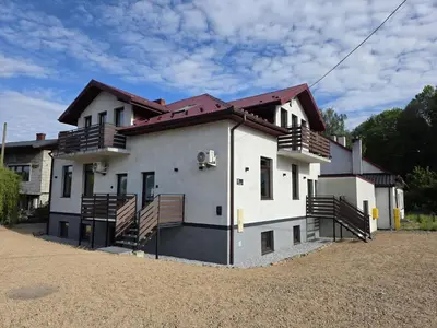 a large white house with wooden balconies on it at La Ville - Rouge in Zator