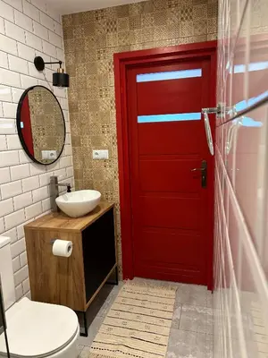 a bathroom with a red door and a sink at La Ville - Rouge in Zator