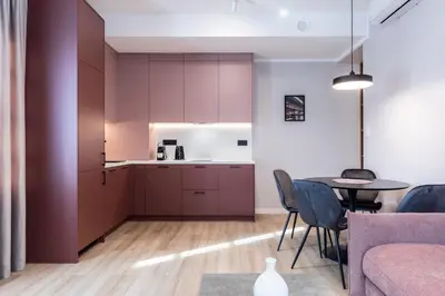 a kitchen with purple cabinets and a table and chairs at Dom Pod Kotwicą in Kraków