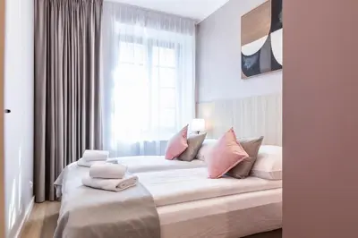 a bedroom with a large white bed with pink pillows at Dom Pod Kotwicą in Kraków