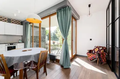 a kitchen and dining room with a table and chairs at Jesionowa Homely Apartment with Garden by BookingHost in Kraków