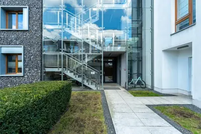 a metal staircase in front of a building at Jesionowa Homely Apartment with Garden by BookingHost in Kraków