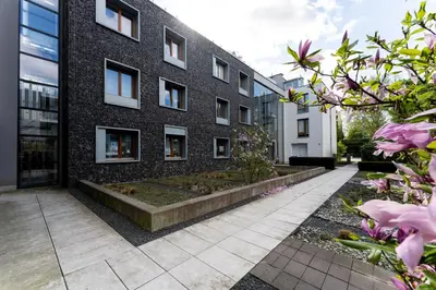 a brick building with a garden in front of it at Jesionowa Homely Apartment with Garden by BookingHost in Kraków