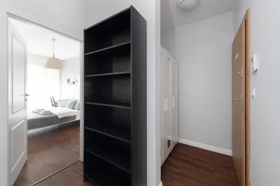 a black book shelf in a room with a bedroom at Kościuszki apartment with parking by Nearto pl in Kraków