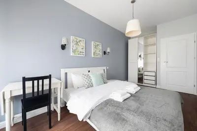 a bedroom with a white bed and a desk at Kościuszki apartment with parking by Nearto pl in Kraków