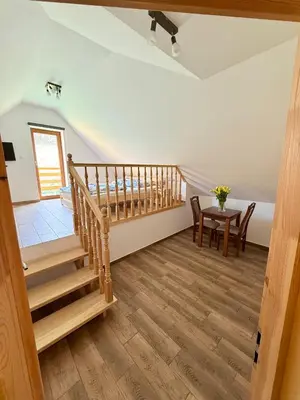 a room with a staircase and a table and chairs at Pod Lachowym Groniem in Koszarawa