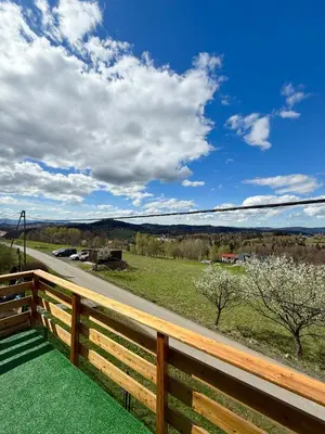 a deck with a fence and a view of a road at Pod Lachowym Groniem in Koszarawa