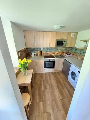 a kitchen with a table and a washing machine at Pod Lachowym Groniem in Koszarawa