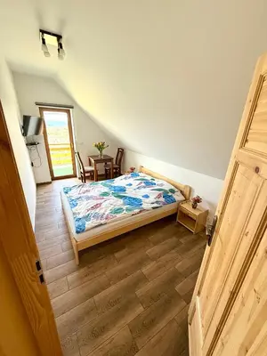 a bedroom with a bed and a wooden floor at Pod Lachowym Groniem in Koszarawa