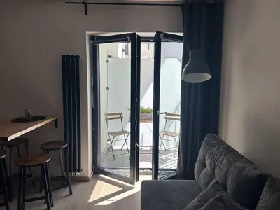 a living room with a couch and a door to a patio at Jungle Apartment in Kraków