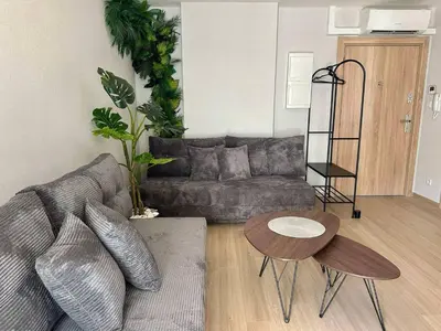 a living room with a couch and a table at Jungle Apartment in Kraków