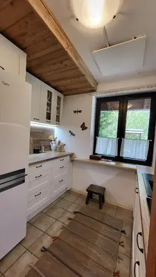 a kitchen with white cabinets and a window at Dom Pod Salamandrą Koninki in Poręba Wielka