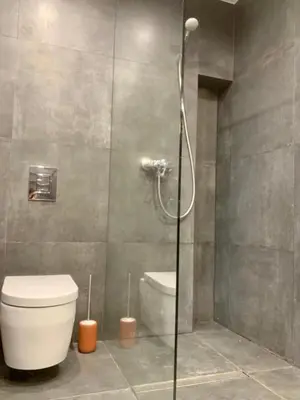 a bathroom with a toilet and a glass shower at Classic Loft Arena in Kraków