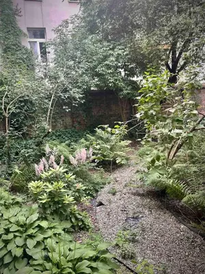 a garden with flowers and plants in front of a building at Classic Loft Arena in Kraków