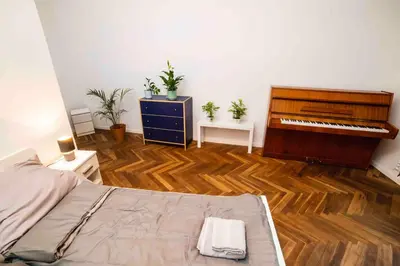 a bedroom with a piano and a wooden floor at Classic Loft Arena in Kraków