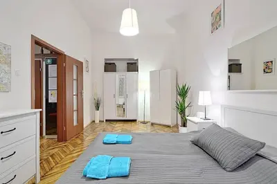 a bedroom with a large bed with blue towels on it at Old Town Apartment in Kraków