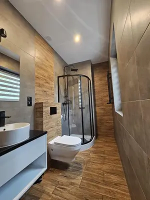 a bathroom with a toilet and a glass shower at Noclegi Primavera in Jaśkowice