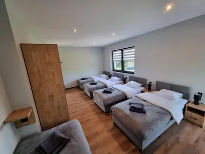 a room with four beds and a couch in it at Noclegi Primavera in Jaśkowice