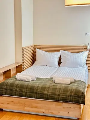 a bed with two pillows on top of it at Four Apartaments Daszyńskiego in Kraków