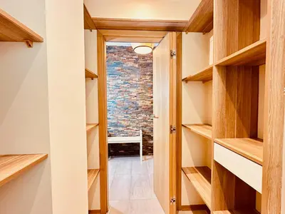 a walk in closet with wooden shelves at Four Apartaments Daszyńskiego in Kraków