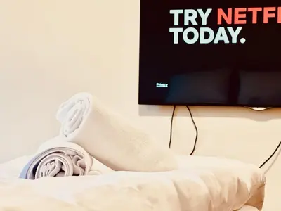 a pair of socks sitting on a bed in front of a tv at Four Apartaments Daszyńskiego in Kraków