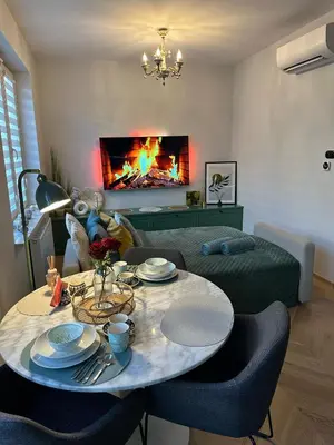 a living room with a table and a fireplace at Heron Apartment - Old Town Kraków in Kraków