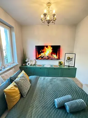 a bedroom with a bed with a fireplace at Heron Apartment - Old Town Kraków in Kraków